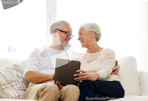 Image of happy senior couple with tablet pc at home