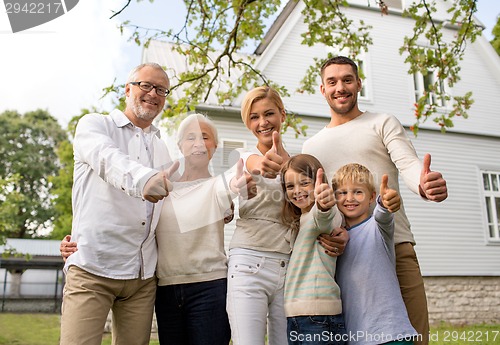 Image of happy family in front of house outdoors