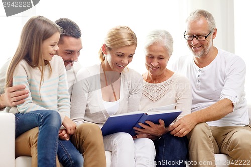 Image of happy family with book or photo album at home