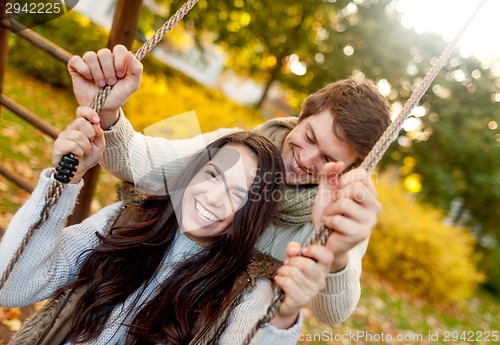 Image of smiling couple hugging in autumn park