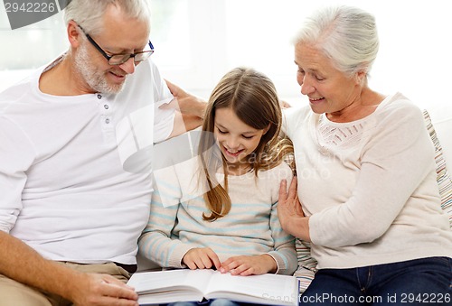 Image of smiling family with book at home