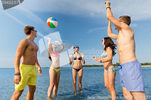 Image of smiling friends in sunglasses on summer beach