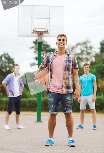 Image of group of smiling teenagers playing basketball