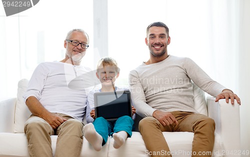 Image of smiling family with tablet pc at home