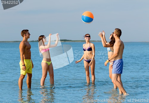 Image of smiling friends in sunglasses on summer beach