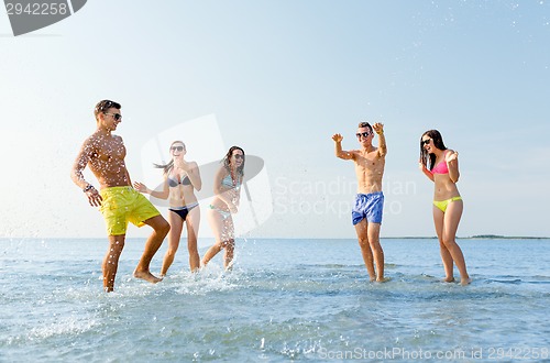 Image of happy friends having fun on summer beach