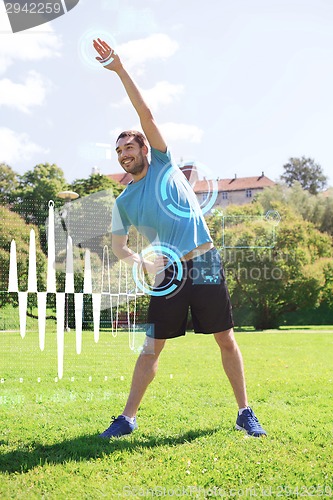 Image of smiling man stretching outdoors