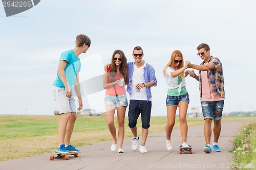 Image of group of smiling teenagers with skateboards