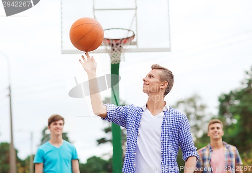 Image of group of smiling teenagers playing basketball