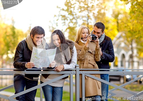 Image of group of friends with map and camera outdoors