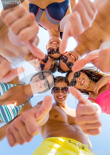 Image of smiling friends showing thumbs up in circle