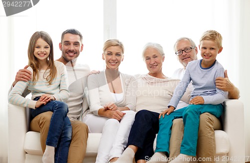 Image of happy family sitting on couch at home