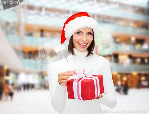 Image of smiling woman in santa helper hat with gift box