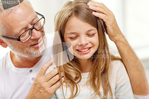 Image of grandfather with crying granddaughter at home