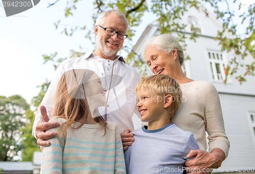 Image of happy family in front of house outdoors