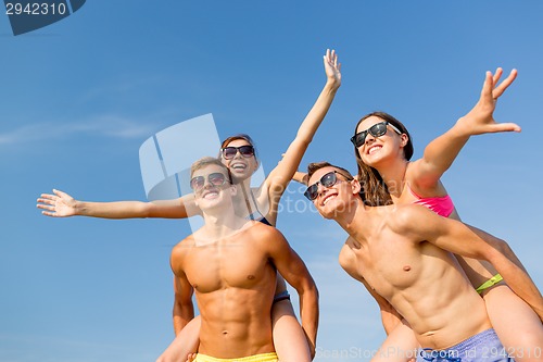 Image of smiling friends having fun on summer beach