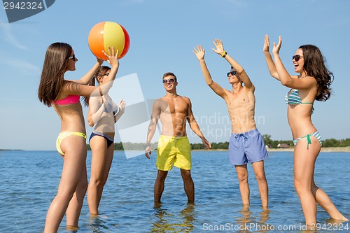 Image of smiling friends in sunglasses on summer beach