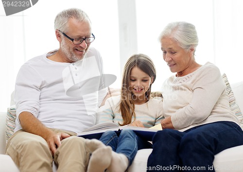 Image of smiling family with book at home