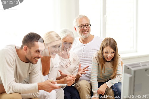 Image of happy family watching tv at home