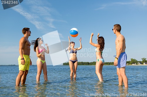 Image of smiling friends in sunglasses on summer beach