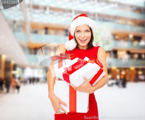 Image of smiling woman in red dress with gift boxes