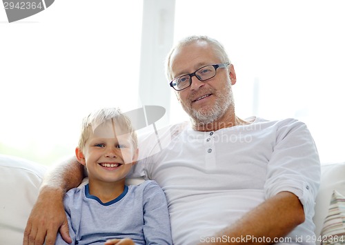 Image of smiling grandfather and grandson at home