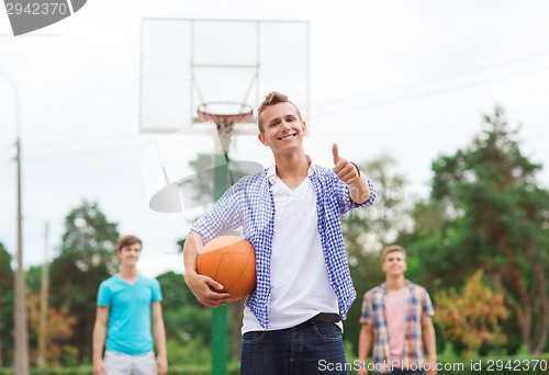 Image of group of smiling teenagers playing basketball