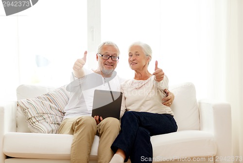 Image of happy senior couple with tablet pc at home