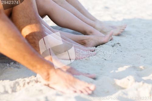 Image of close up of friends sitting on summer beach