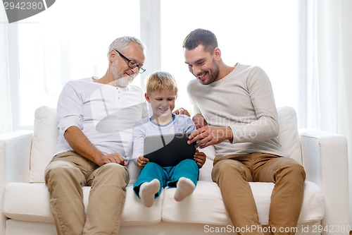 Image of smiling family with tablet pc at home