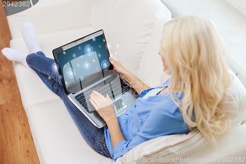 Image of smiling woman with laptop computer at home