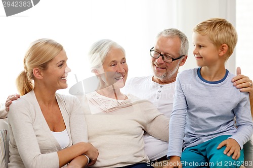 Image of happy family sitting on couch at home