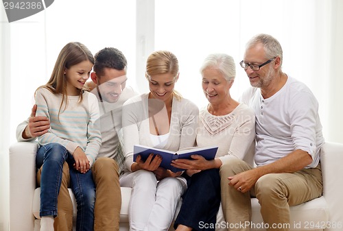 Image of happy family with book or photo album at home