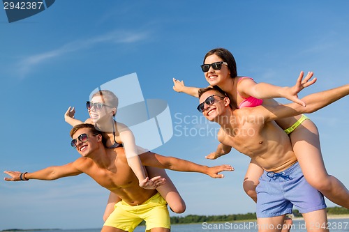 Image of smiling friends having fun on summer beach