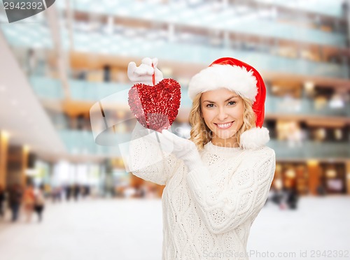 Image of smiling woman in santa helper hat with red heart