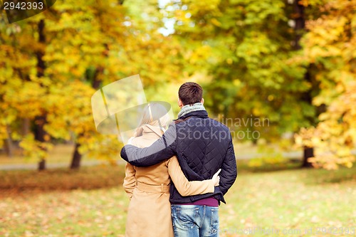 Image of couple hugging in autumn park from back