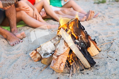 Image of close up of friends sitting on summer beach