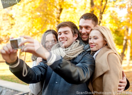Image of group of smiling men and women making selfie