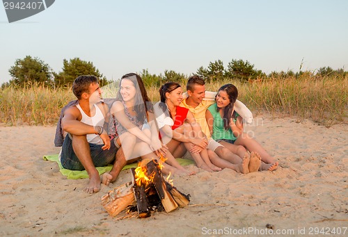 Image of smiling friends in sunglasses on summer beach