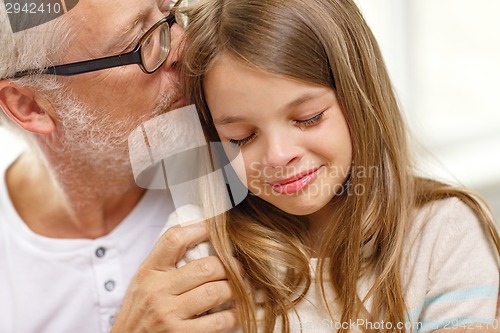 Image of grandfather with crying granddaughter at home