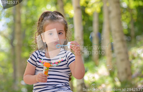 Image of little girl blowing soap bubbles