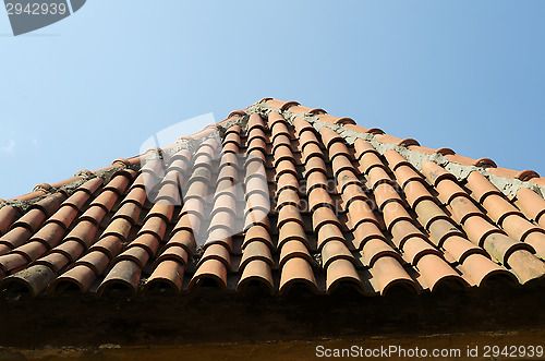 Image of old tile roof on blue sky