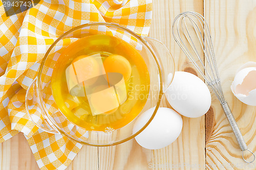 Image of Raw eggs and whisk