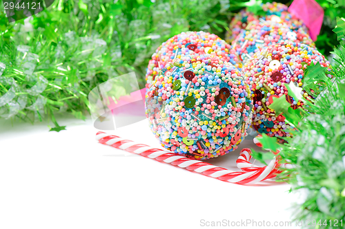 Image of Green tinsel with Christmas balls and candy canes