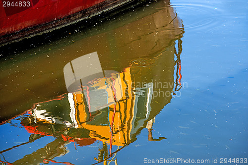 Image of reflection of a boat in a port