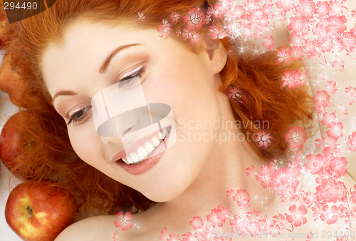 Image of lovely redhead with red apples and flowers