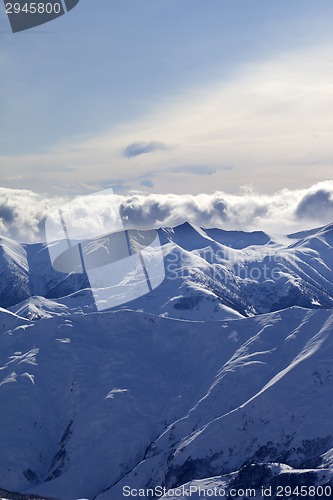 Image of Snowy mountains and sunlight clouds at evening