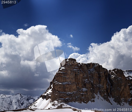 Image of Panorama of snowy rocks and sky with sunbeam in nice spring day