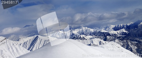 Image of Off-piste snowy slope and cloudy mountains