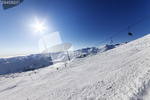 Image of Off-piste slope and blue sky with sun